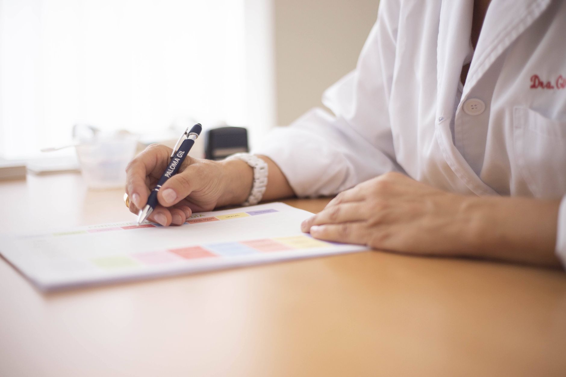 pexels-photo-16204070 close up of a doctor sitting at a desk and writing on paper